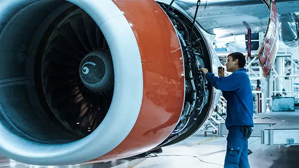 jet-engine-iStock-1022905038-600×338 Mann inspiziert ein Strahltriebwerk